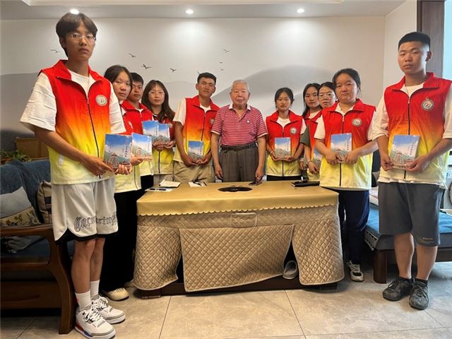 杨昭儒老爷爷向同学们赠送书籍。