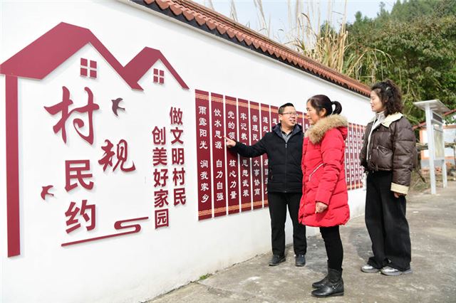 村民在三官村里阅读村规民约。郭明摄